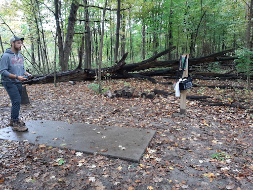 A person prepares on a project site, suggesting Drain Bros llc plans carefully for plumbing work in natural areas.