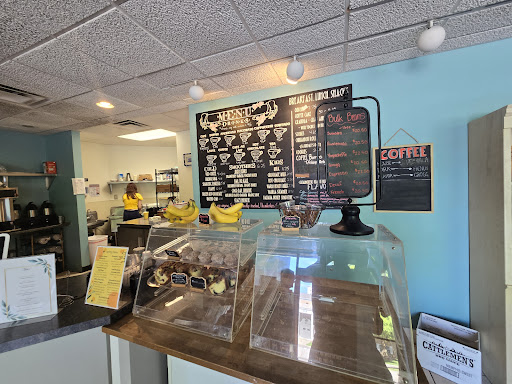 Drain Bros llc signs in a bakery show they install septic systems while staff work behind the counter serving pastries.