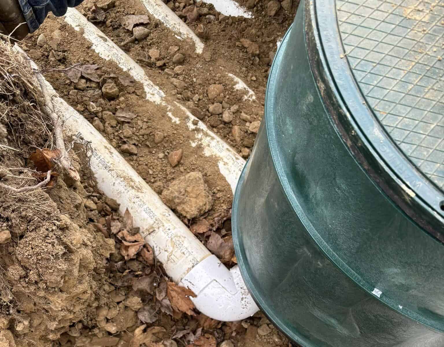 Drain Bros llc installing new drainage system for a home, showing work in progress to manage water safely.