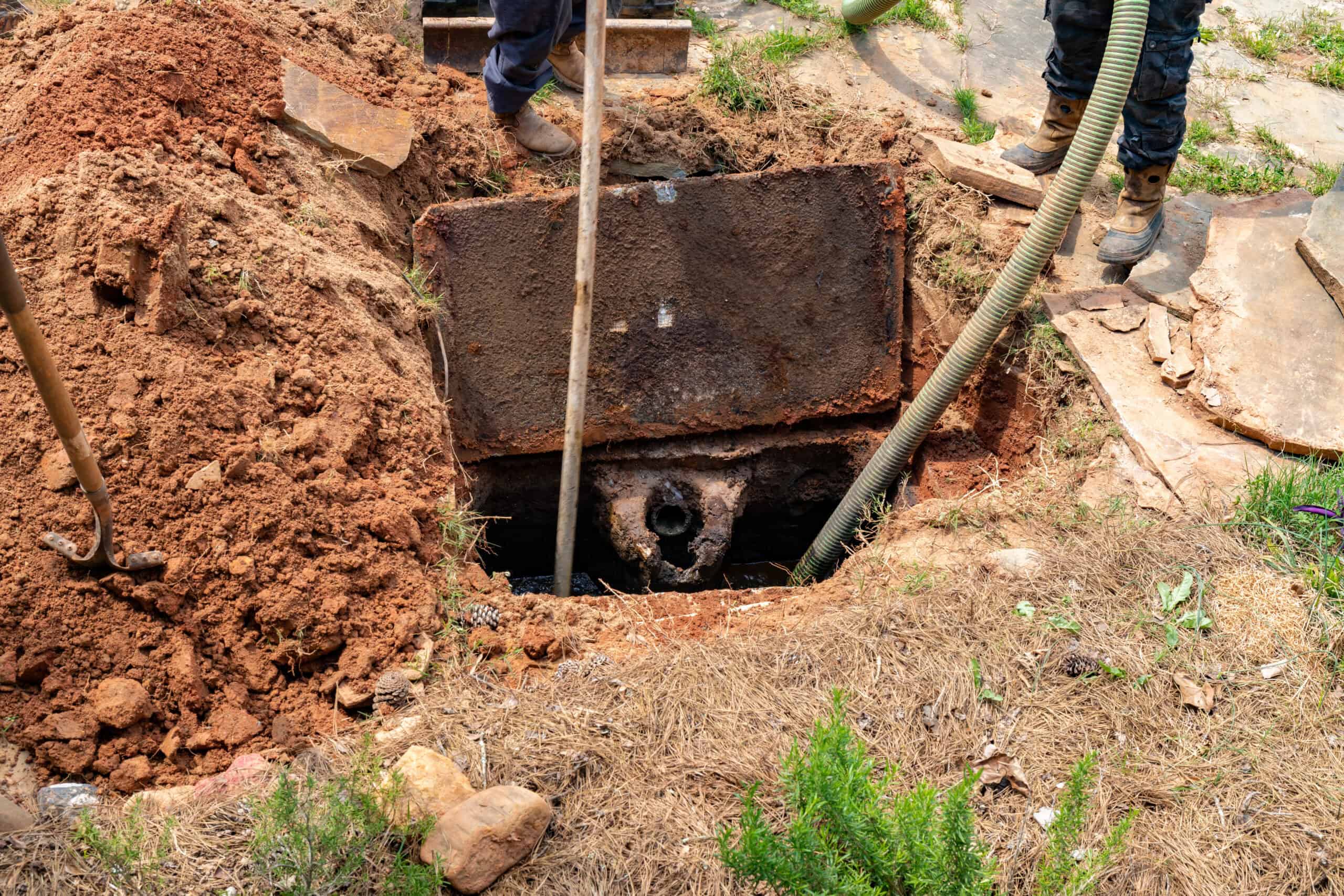 Drain Bros llc technicians working on septic tank maintenance or repairs, showing care and attention to sewer issues.