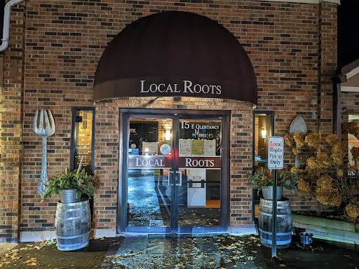 Outside Local Roots restaurant, Drain Bros llc banners show plumbing and drainage system installation services nearby.