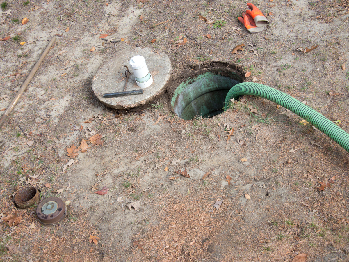 Drain Bros llc cleaning a septic tank, using equipment and tools for plumbing service and maintenance work.