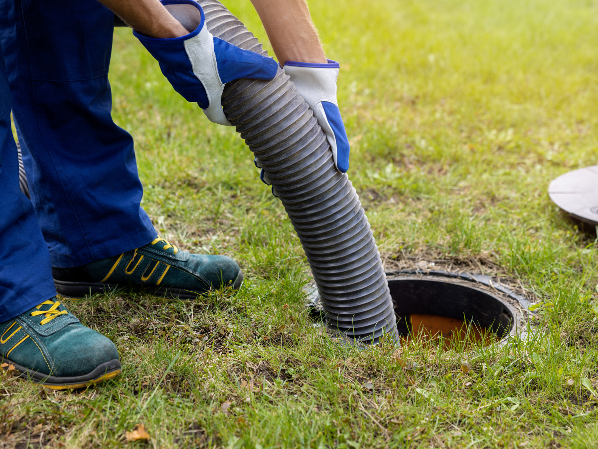 Drain Bros llc employee works on a septic tank, showing expert help for outdoor sewer or septic system needs.