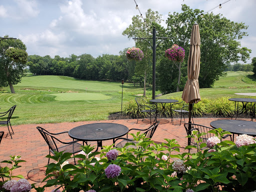 Drain Bros llc improved proper drainage for a relaxing patio area next to a golf course with plants and lights.