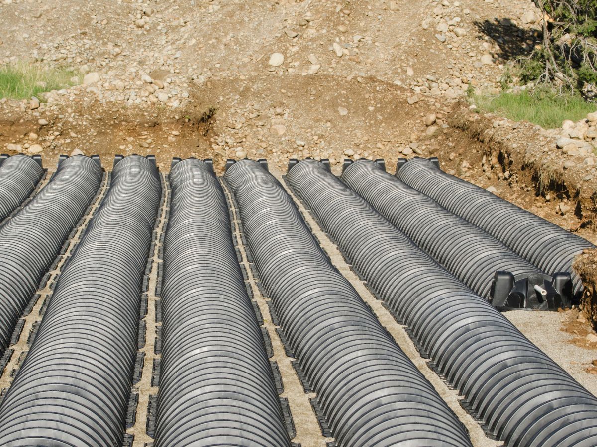 Drain Bros llc installing a drainage system at a construction site, showing progress in plumbing and excavation work.