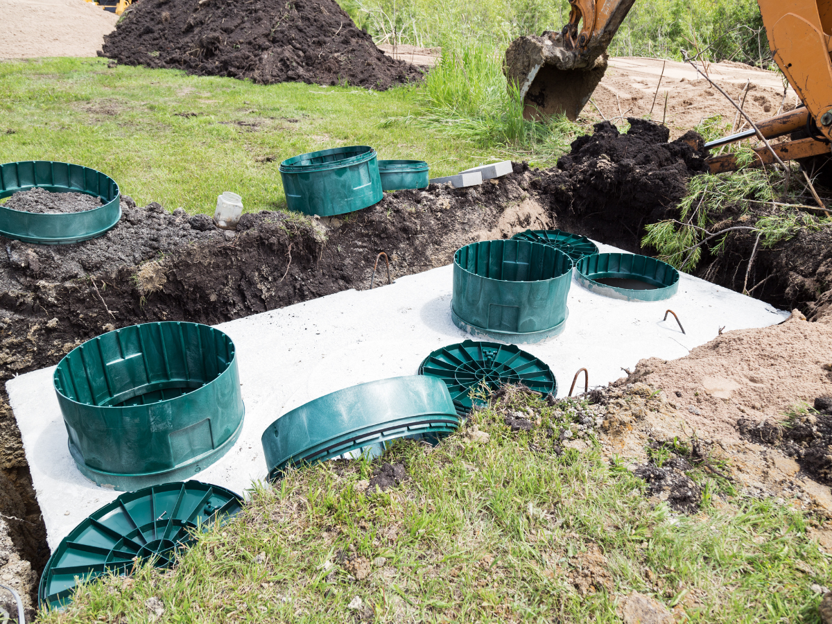Drain Bros llc works on a drainage system, showing active construction with new septic tanks being installed.