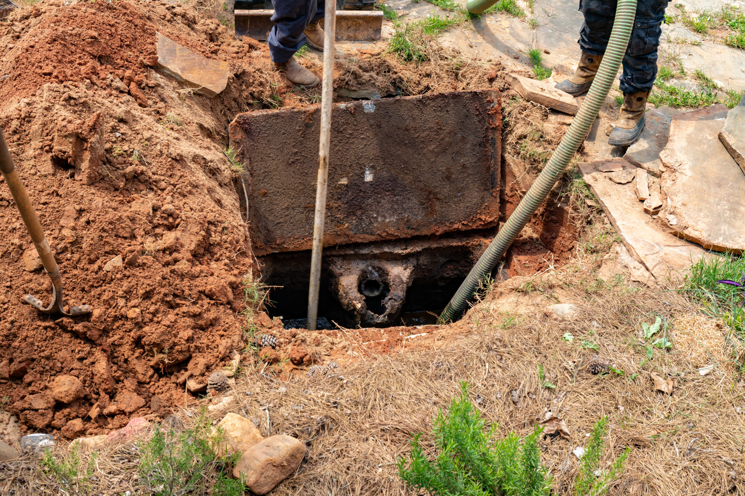 Drain Bros llc workers handle septic tank maintenance, showing expertise in fixing drainage systems safely and efficiently.