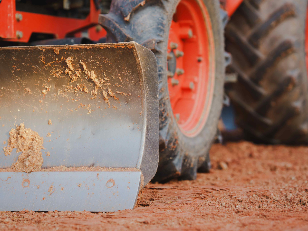 A Drain Bros llc tractor shown working hard on soil, showing how they handle tough digging and moving jobs.