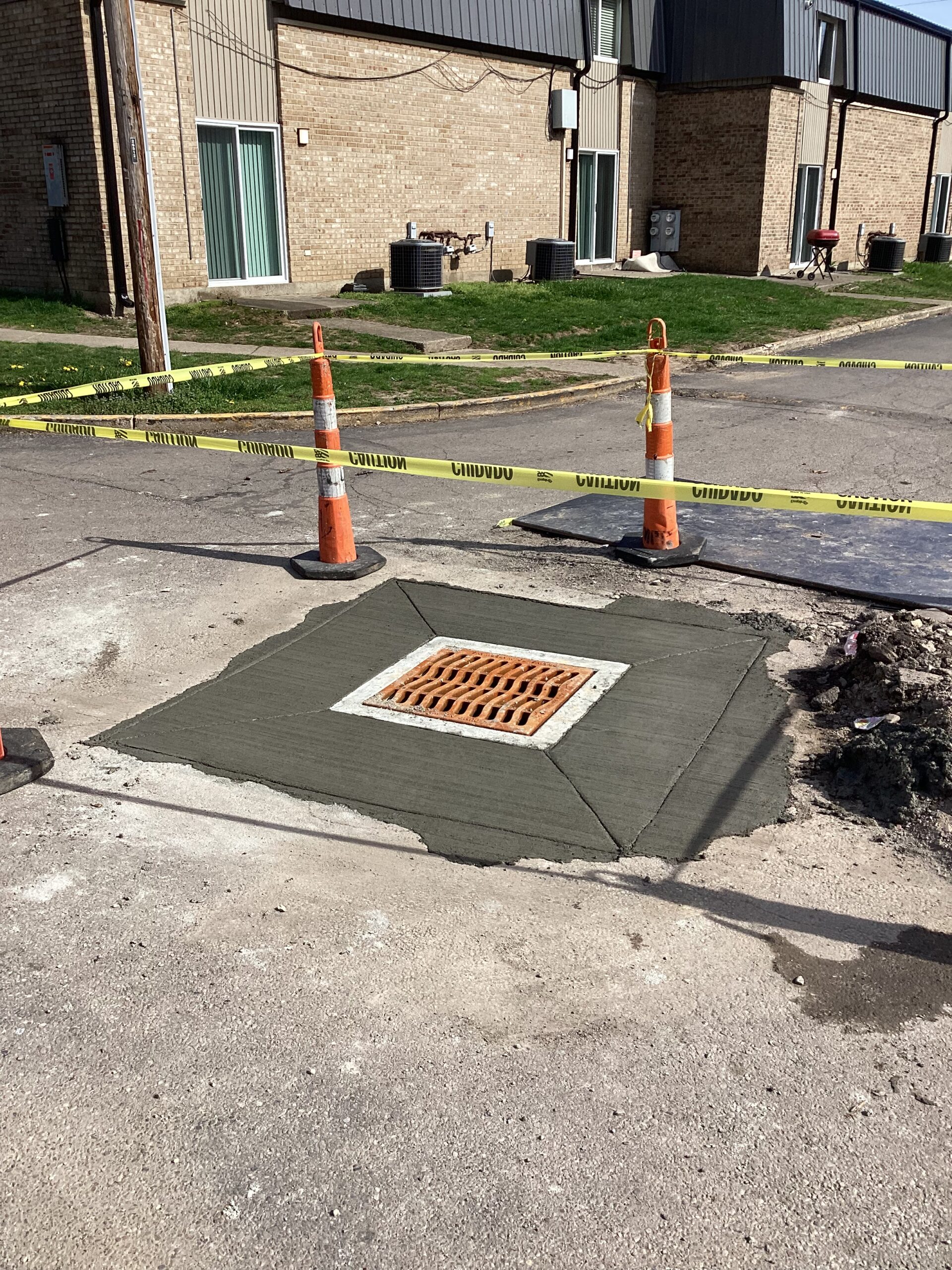 Drain Bros llc just finished installing a new storm drain on a city street after plumbing and safety work was done.