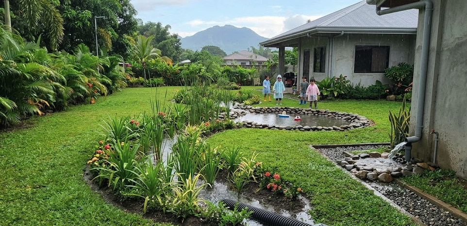 Children play in a garden, showing how Drain Bros llc keeps homes safe with proper drainage and sewer solutions.