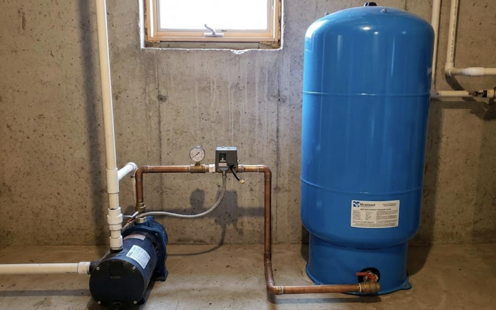 Drain Bros llc installed a reliable well water tank and pump system in a basement to provide steady household water.
