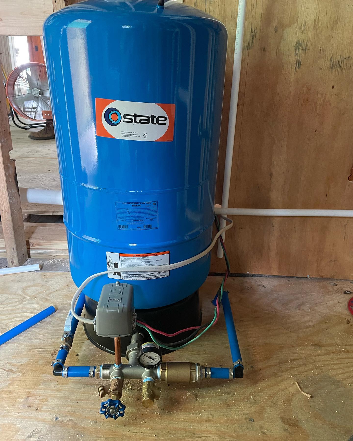 A Drain Bros llc pressure tank system in a utility room helps manage water flow for home plumbing and excavation needs.